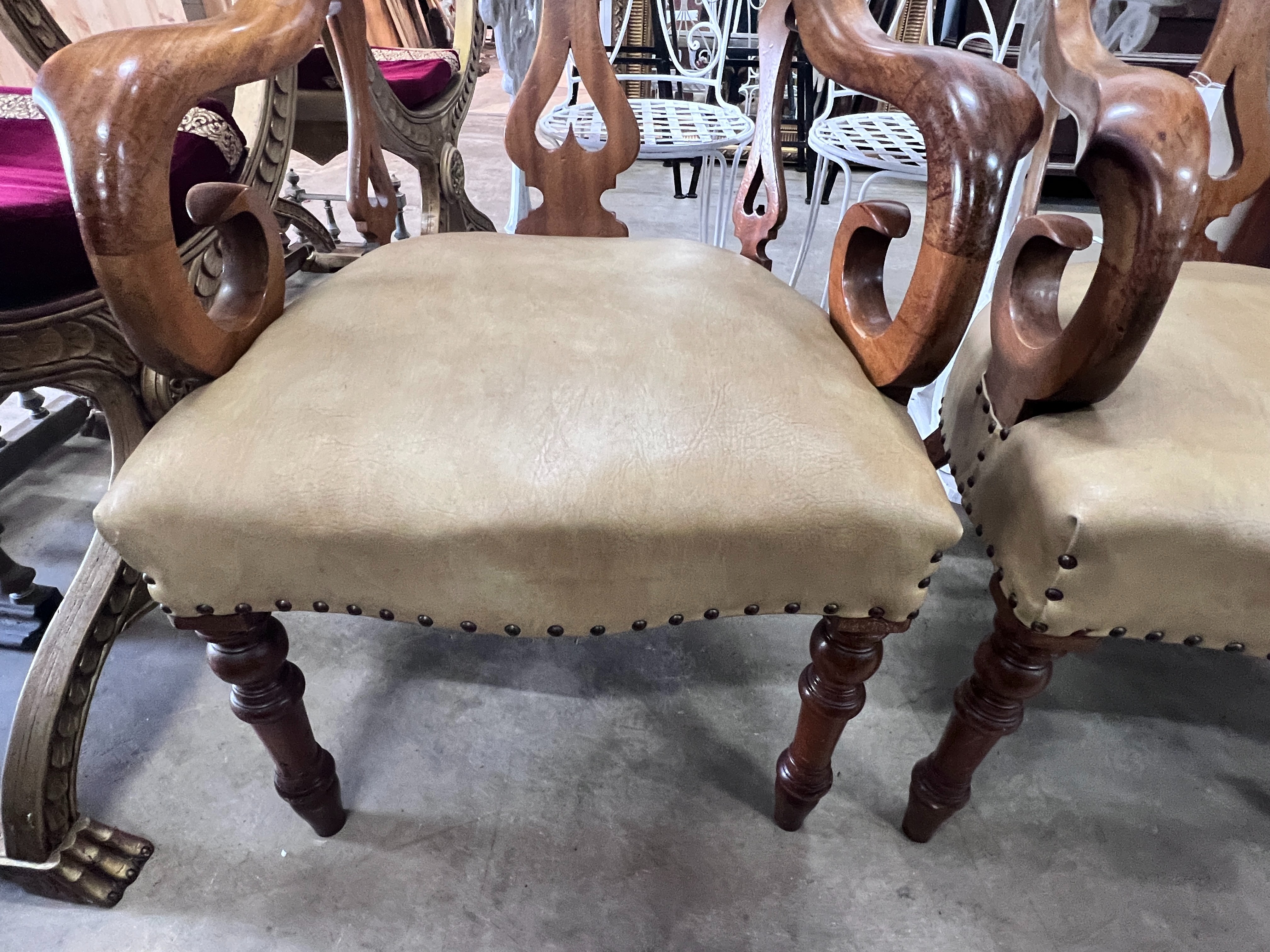 A pair of Victorian walnut elbow chairs with light brown leather seats, width 59cm, depth 51cm, height 90cm